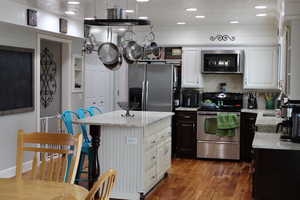 Kitchen with light stone countertops, decorative backsplash, stainless steel appliances, and a center island