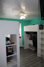 Bedroom 3 featuring ceiling fan, dark hardwood / wood-style floors, and a textured ceiling