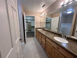 Primary bathroom featuring vanity and a textured ceiling