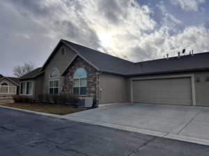 Ranch-style home with a garage and cooling unit