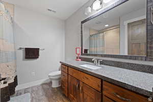 Bathroom with wood-type flooring, toilet, and vanity