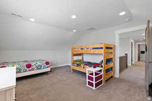 Carpeted bedroom with lofted ceiling