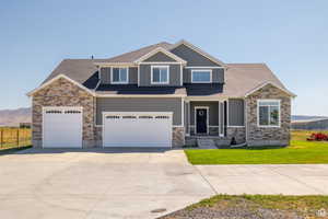 Craftsman-style home with a mountain view, a garage, and a front lawn