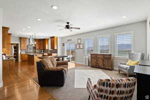 Living room with a healthy amount of sunlight, sink, ceiling fan, and light hardwood / wood-style flooring