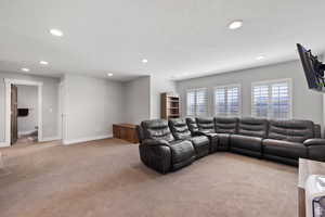 Living room with light colored carpet and a textured ceiling