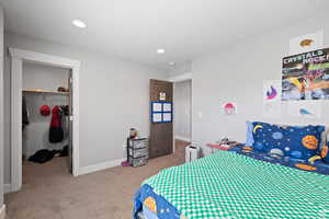 Carpeted bedroom with a spacious closet and a closet