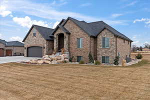 View of front facade featuring a garage, cooling unit, and a front lawn