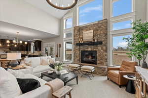 Carpeted living room with a fireplace and an inviting chandelier