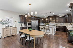 Dining space featuring sink, dark wood-type flooring, and a chandelier