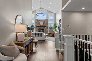 Hall featuring dark wood-type flooring, a notable chandelier, and high vaulted ceiling