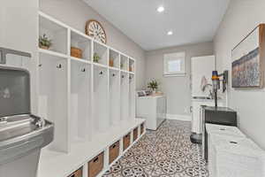 Mudroom with separate washer and dryer and sink