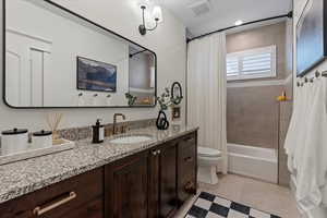 Full bathroom with shower / tub combo with curtain, vanity, toilet, and tile patterned flooring