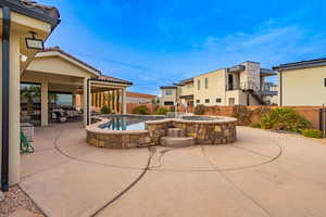 View of patio with a pool with hot tub