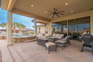 View of patio / terrace featuring ceiling fan, an outdoor hangout area, and a pool with hot tub