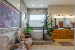 Bathroom with vanity, tile patterned floors, and a bathing tub