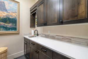 Kitchen featuring dark brown cabinetry and sink