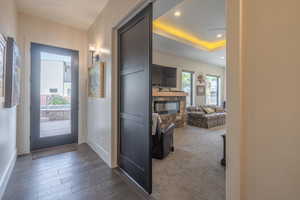 Corridor featuring dark wood-type flooring and a tray ceiling