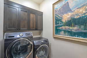 Laundry area with cabinets and washing machine and clothes dryer