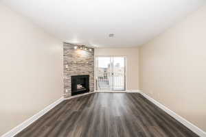 Unfurnished living room with dark hardwood / wood-style flooring and a large fireplace