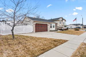 View of front of property featuring a garage and a front lawn