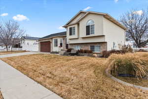 Tri-level home with a garage and a front lawn