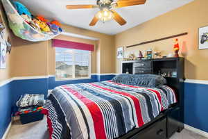 Carpeted bedroom featuring ceiling fan