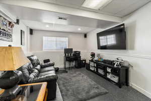 Carpeted living room featuring a drop ceiling