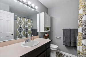 Bathroom featuring vanity, toilet, and hardwood / wood-style floors