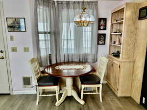 Dining area with light hardwood / wood-style flooring and a chandelier