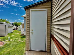 Doorway to property featuring a lawn