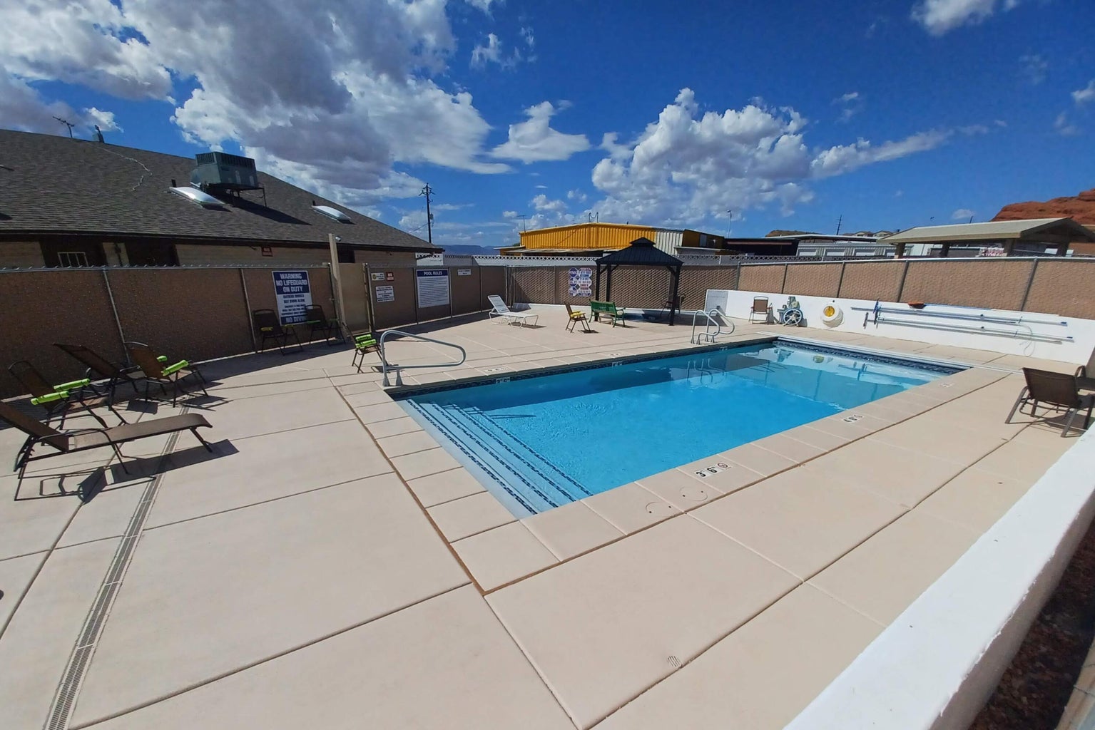 Pool with a patio and fence