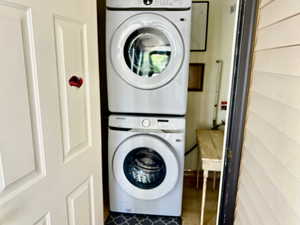Washroom featuring laundry area and stacked washing maching and dryer