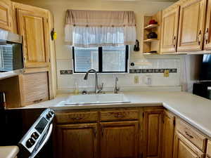 Kitchen with tasteful backsplash, sink, and stainless steel appliances