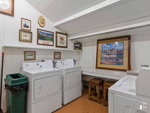 Laundry room with wood ceiling and washing machine and clothes dryer