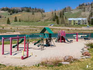 View of jungle gym with a water view