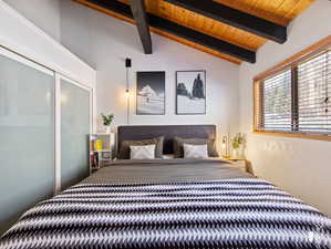 Bedroom with wood ceiling and vaulted ceiling with beams