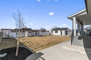 View of the backyard with a detached garage and a patio