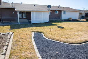 Rear view of property with a yard