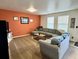 Carpeted living room featuring a textured ceiling