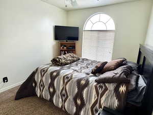 Bedroom featuring a textured ceiling, ceiling fan, and carpet