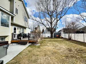 View of yard with a wooden deck and a patio