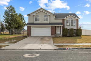 View of front of property with a garage and a front lawn