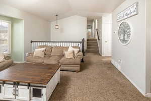 Living room featuring vaulted ceiling and light colored carpet