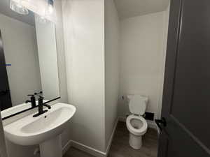 Bathroom featuring wood-type flooring, toilet, and sink