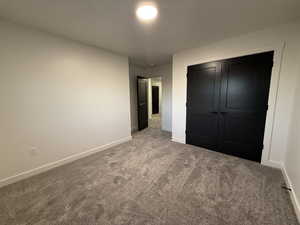 Unfurnished bedroom featuring carpet floors and a closet