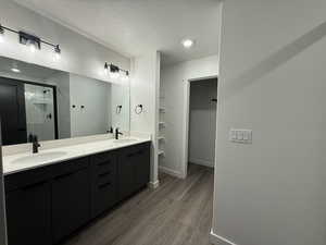 Bathroom featuring vanity, an enclosed shower, wood-type flooring, and a textured ceiling