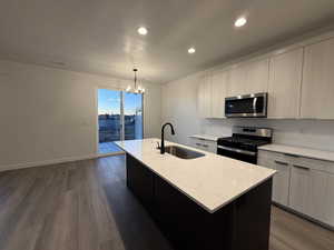 Kitchen with appliances with stainless steel finishes, sink, and a kitchen island with sink