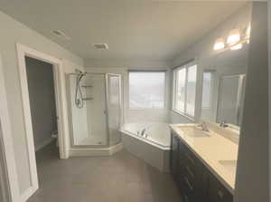 Full bathroom with vanity, tile patterned floors, and plus walk in shower