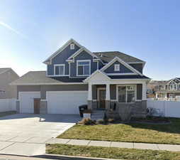 Craftsman-style home with a garage and a front lawn