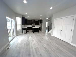 Kitchen with appliances with stainless steel finishes, sink, a kitchen bar, a center island, and light wood-type flooring